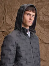 Campera de nylon termosellada con capucha, color azul marino, con cierre frontal y detalles en color naranja en el borde del cierre y costuras de la capucha.