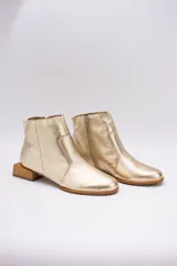 Botín de cuero dorado con punta fina y taco bajo cuadrado de madera.