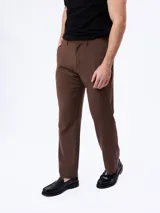Traje slim color marrón de dos piezas, compuesto por un saco entallado de dos botones y un pantalón de corte recto. Confeccionado en mezcla de lana y poliéster.