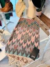 Pashmina rectangular con diseño de corazones entrelazados y flecos en los extremos.