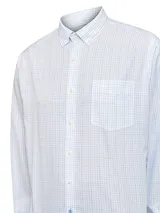 Camisa de manga larga RKF con estampado de cuadrícula fina en tonos azules y verdes sobre fondo blanco. Presenta cuello americano abotonado, cierre frontal con botones, puños ajustables y un bolsillo en el pecho con el logo de la marca bordado.