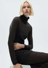 Jersey de punto fino con diseño semitransparente, cuello alto y manga larga. Presenta un corte recto y tejido de textura ligera.