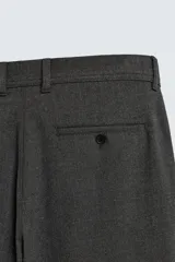 Pantalón chino negro slim fit de corte recto, con bolsillos frontales, trabillas para cinturón y cierre frontal con cremallera y botón.