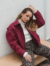 Campera gris con cierre frontal, cuello camisero y mangas largas con puños elásticos.