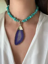 Collar corto con cuentas de turquesa irregulares y dije colgante de ágata púrpura con borde dorado.
