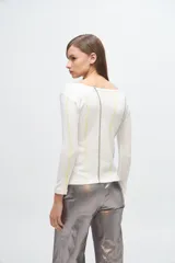 Remera de manga larga en color gris melange, con cuello redondo y costuras decorativas verticales en contraste de color verde lima y blanco.