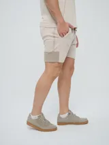 Bermuda Umbro de hombre, color beige, confeccionada en tejido de algodón con bolsillos laterales y cintura elástica con cordón de ajuste.