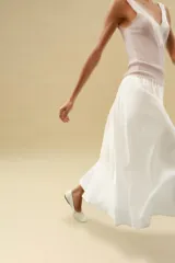 Top de punto canalé en color beige, con escote en pico adornado con una delicada aplicación de encaje blanco y tirantes anchos.