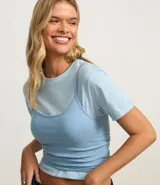 Blusa cropped blanca de algodón con breteles finos.