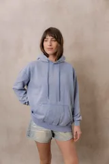 Canguro oversize fucsia con efecto washed, capucha con cordones ajustables al tono, bolsillo frontal tipo canguro y terminaciones de rib en puños y cintura.