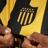 Camiseta de fútbol Puma del C.A. Peñarol, modelo Home Jersey, con diseño de rayas verticales amarillas y negras.