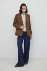Blazer de paño con estampado de cuadros en tonos marrones, con solapas clásicas, hombreras, cierre frontal con un botón y botones decorativos en los puños.