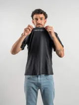 Remera de corte oversize color marrón con efecto lavado, cuello redondo y estampa frontal con la frase 'URUGUAY noma!'.