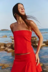 Top strapless rojo confeccionado en lino y rayón, con elástico y lazo para atar en la espalda.