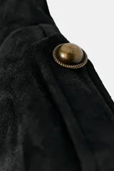 Cazadora negra efecto ante de cuello redondo, manga larga con botones en los hombros, detalle de alamares en el delantero y cierre frontal con cremallera.