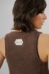 Chaleco de denim azul con cuello en V, cierre frontal con botones metálicos y pespuntes en contraste.