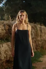 Vestido midi de lino y rayón, color negro, con escote recto, tirantes finos ajustables y tajo lateral.