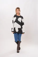 Buzo oversize de punto con estampado de manchas de vaca en blanco y negro.