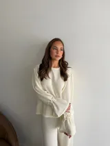 Buzo de textura arrugada color marrón chocolate, con cuello redondo y mangas largas con puños acampanados y fruncidos.