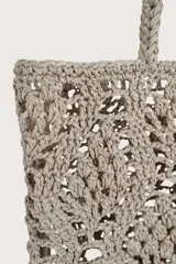 Bolsa tipo tote tejida en crochet con diseño de diamantes, color beige, con asas trenzadas y etiqueta colgante de cuero sintético color suela.