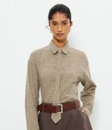 Camisa oversized de algodón con estampado de cuadros, cuello camisero clásico, mangas largas y corbata confeccionada en el mismo tejido.
