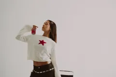 Sweater de punto color crema con una estrella roja en el centro.