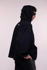 Canguro oversize confeccionado en denim negro 100% algodón, con capucha, cuello alto con cierre metálico frontal, bolsillo frontal tipo canguro y puños con elástico.