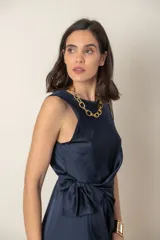 Vestido midi negro de satén, corte recto, sin mangas, con lazo lateral y cuello redondo.