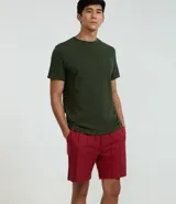 Bermuda recta de playa en color blanco roto, confeccionada en algodón texturizado con efecto de rayas verticales. Posee cintura elástica con cordón ajustable.