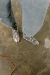 Zapatillas bajas de cuero color crema con detalles en marrón y cordones blancos.