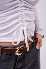 Crop top marrón de manga larga, con escote en V pronunciado, cuello tipo polo y detalle de frunce regulable en el centro del pecho.