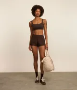 Bermuda runner deportiva de microfibra color marrón, con cintura elástica ancha, bajo redondeado y bolsillo funcional con cierre. Diseño holgado ideal para actividades físicas.