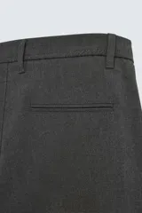 Pantalón de corte slim fit confeccionado en tejido elástico, con cintura elástica, cierre frontal con cremallera y botón, bolsillos laterales y bolsillos traseros de vivo.