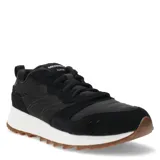 Championes urbanos Merrell modelo Alpine 83, color negro con detalles en blanco y suela de goma color caramelo. Presentan una combinación de texturas en gamuza y material sintético, con cierre de cordones y logo de la marca en la lengüeta.