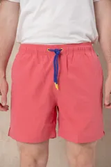 Short de baño color salmón, con cintura elástica y cordón de ajuste azul con terminales amarillas.