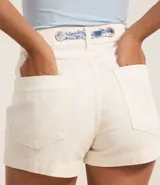Short de jeans color crudo, de corte slim y cintura alta. Incluye cinturón tipo pañuelo con estampado floral.