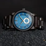 Reloj Chenaut Saphir d’Ébène con movimiento de cuarzo, caja y malla de madera de ébano, esfera azul zafiro con detalles dorados, cristal Hardlex resistente a los arañazos y cierre oculto con botón.