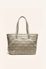 Cartera tipo tote bag confeccionada en cuero vacuno trenzado a mano, color beige. Cuenta con doble asa de hombro, forro interior, cierre exterior y bolsillos internos.