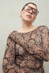 Top de manga larga de tejido translúcido con estampado animal print en tonos marrones, negros y beige.