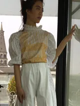 Remera blanca de algodón con estampado color cobre y mangas de broderie negro con elástico.