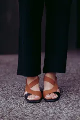 Sandalias de cuero color marrón y negro, con tiras cruzadas y taco de 6 cm.