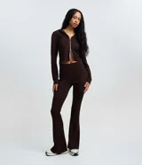 Pantalón flare marrón de cintura ancha, corte ajustado en caderas y muslos con botamanga acampanada.