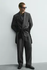 Pantalón de corte relaxed fit confeccionado en tejido 100% lino. Presenta cintura con cierre de cremallera y botón, pliegues frontales, bolsillos laterales y bolsillos traseros de vivo.