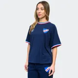 Remera de fútbol Umbro del Club Nacional de Football para mujer. Diseño azul con detalles tricolor en cuello y mangas. Incluye logo de Umbro y escudo del club en el frente.