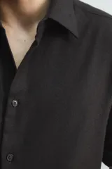 Camisa de corte relajado confeccionada en una mezcla de lana y viscosa. Presenta cuello clásico, manga larga con puños abotonados y cierre frontal con botones a tono.