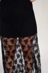 Pollera larga negra con viso, confeccionada en encaje floral. Tiene elástico en la cintura.