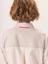 Camisa de manga larga con diseño combinado. Presenta mangas y parte superior delantera y trasera en color negro liso, mientras que el panel central de la espalda destaca por un estampado animal print de leopardo. Cuenta con cuello clásico, cierre frontal de botones y puños abotonados.