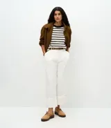 Remera de corte boxy confeccionada en algodón, con diseño de rayas horizontales en blanco y negro, cuello redondo en color negro contrastante y mangas cortas.