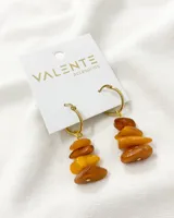 Par de aros colgantes con argolla dorada y dije de ámbar apilado.