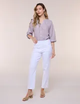 Pantalón ankle de tiro alto color blanco, confeccionado en tejido elástico con pretina ancha tipo pull-on, corte entallado y detalle de encaje calado en las aberturas laterales del ruedo.
